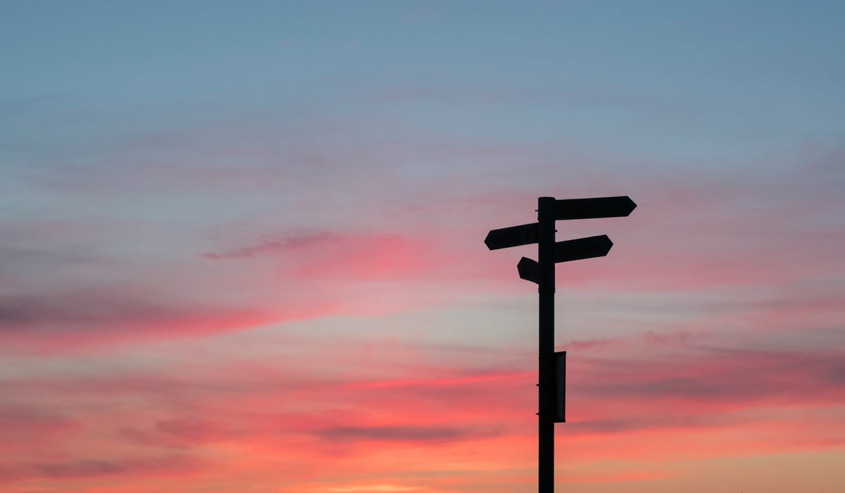 Vägskäl som symboliserar valet mellan aktivt och passivt förhållningssätt till AI i programmering